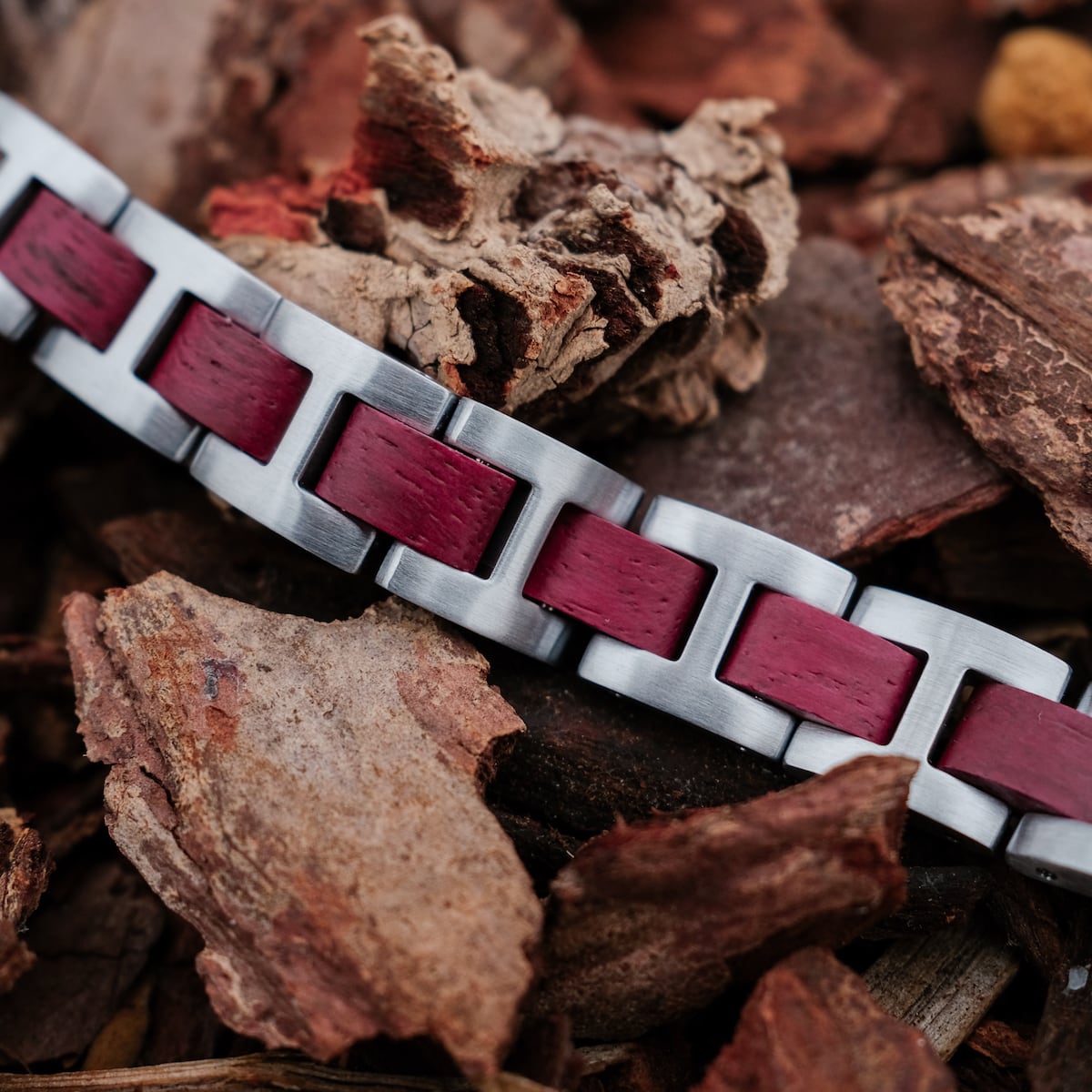 "Acoustic" bracelet featuring amaranth and silver, set against earthy textures for a rustic style.