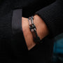 "Staccato", un elegante bracciale con elementi in noce e argento antico, esposto su un polso.