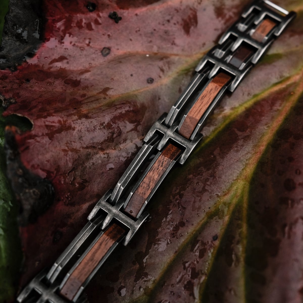 Bracciale "Staccato" con accenti in noce e argento antico su fondo foglia.