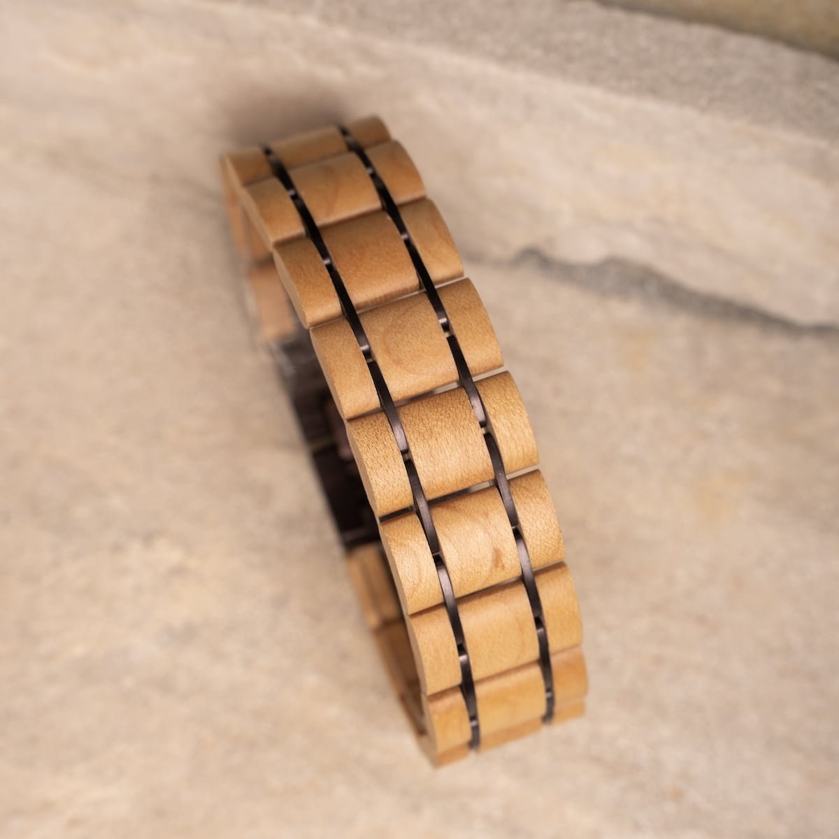 Bracciale "Grandezza", con acero e materiali viola scuro in un design elegante e moderno.
