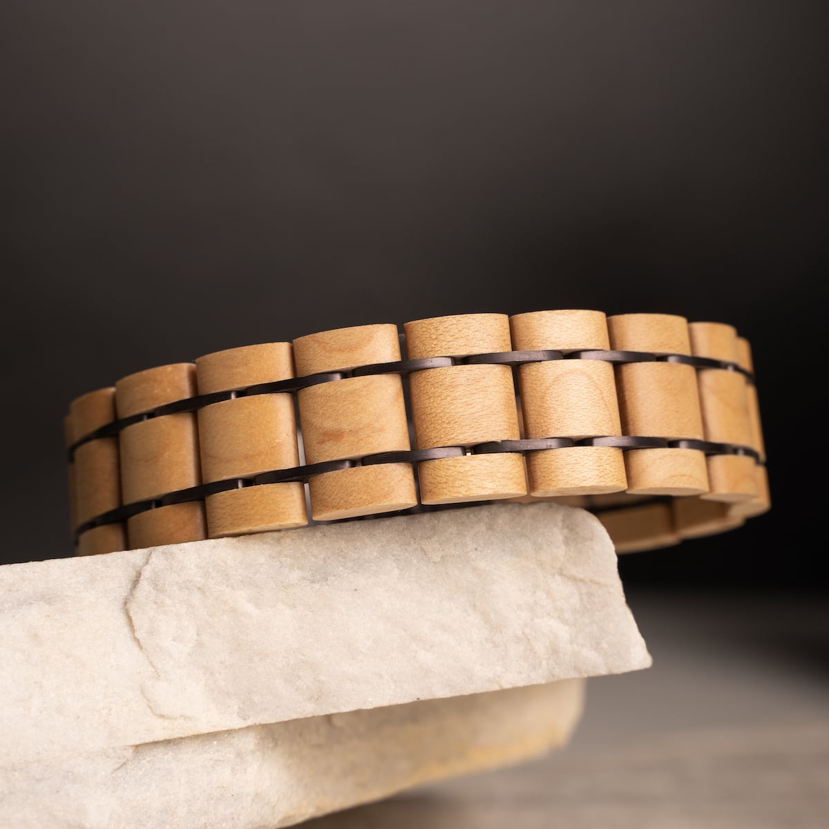 Bracciale in legno "Grandezza" in tonalità acero e viola scuro, che mostra un design elegante e contemporaneo.