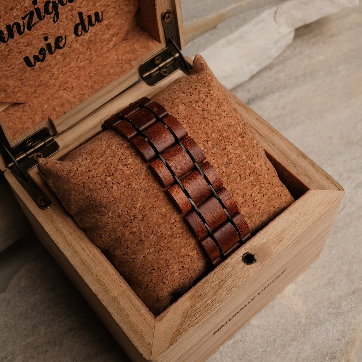 "Grandezza watch with a mahogany and gray design, nestled in a cork-lined wooden box."