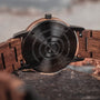 Orologio "Leonardo" con accenti in legno di noce e marmo, caratterizzato da un design rustico e naturale.