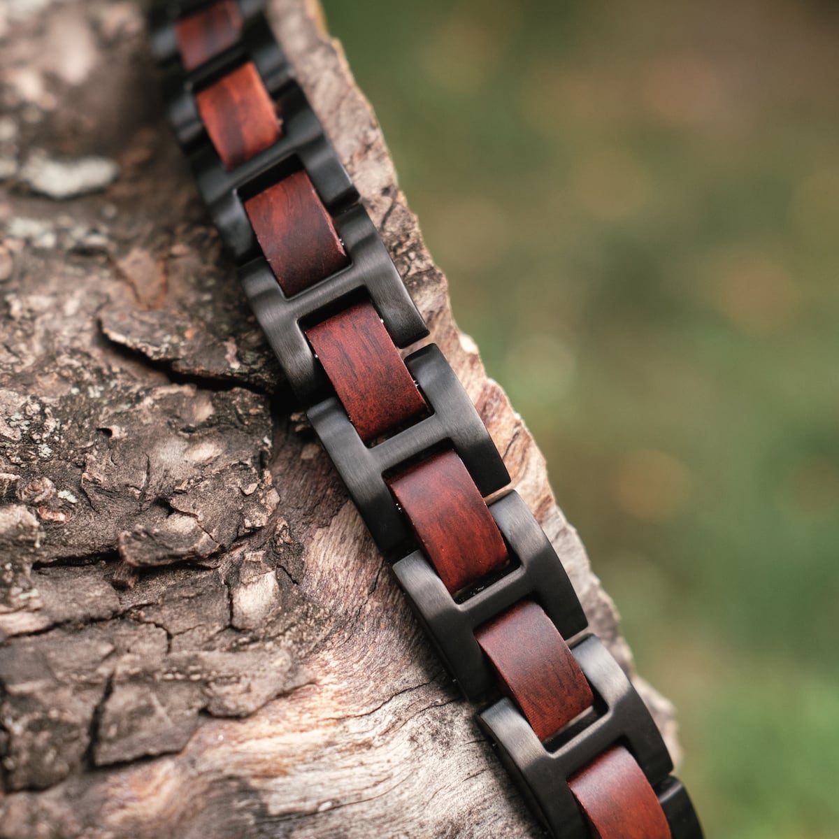 "Acoustic", a stylish watch with a bold Padauk and black color scheme, elegantly displayed on rough wood.