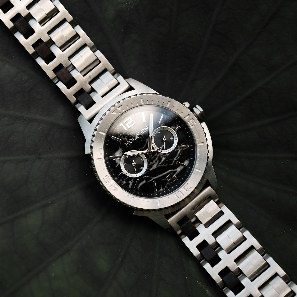 "Norium watch featuring a marble-patterned dial and silver band, combining elegance and modern style."