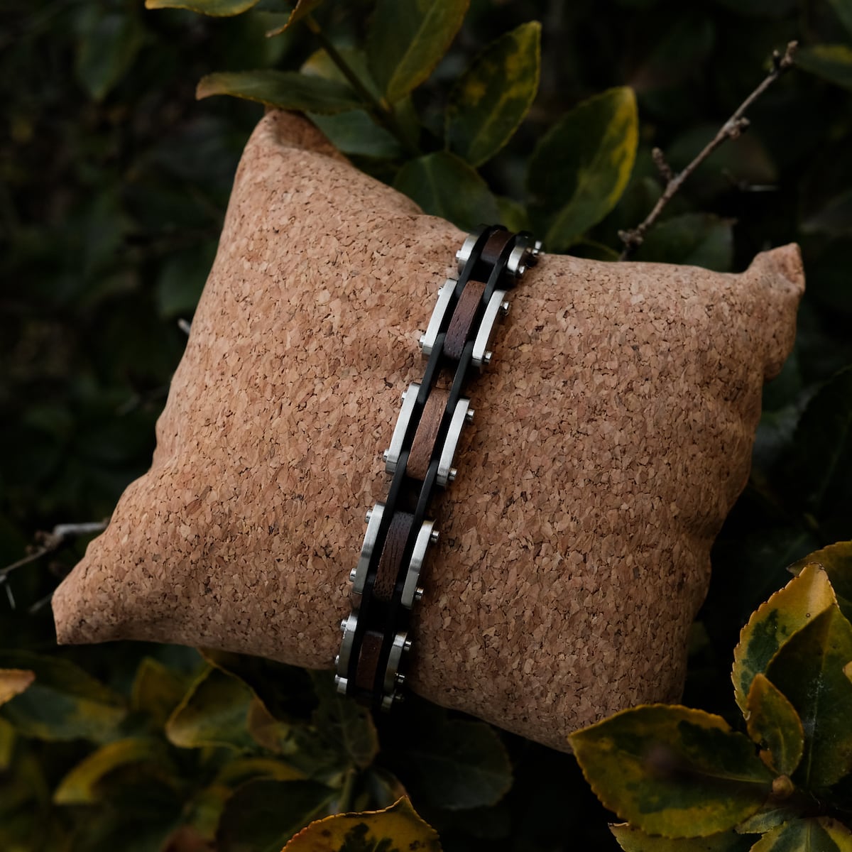 "Allegro", a stylish bracelet, featuring a walnut and silver combination on a cork cushion background.