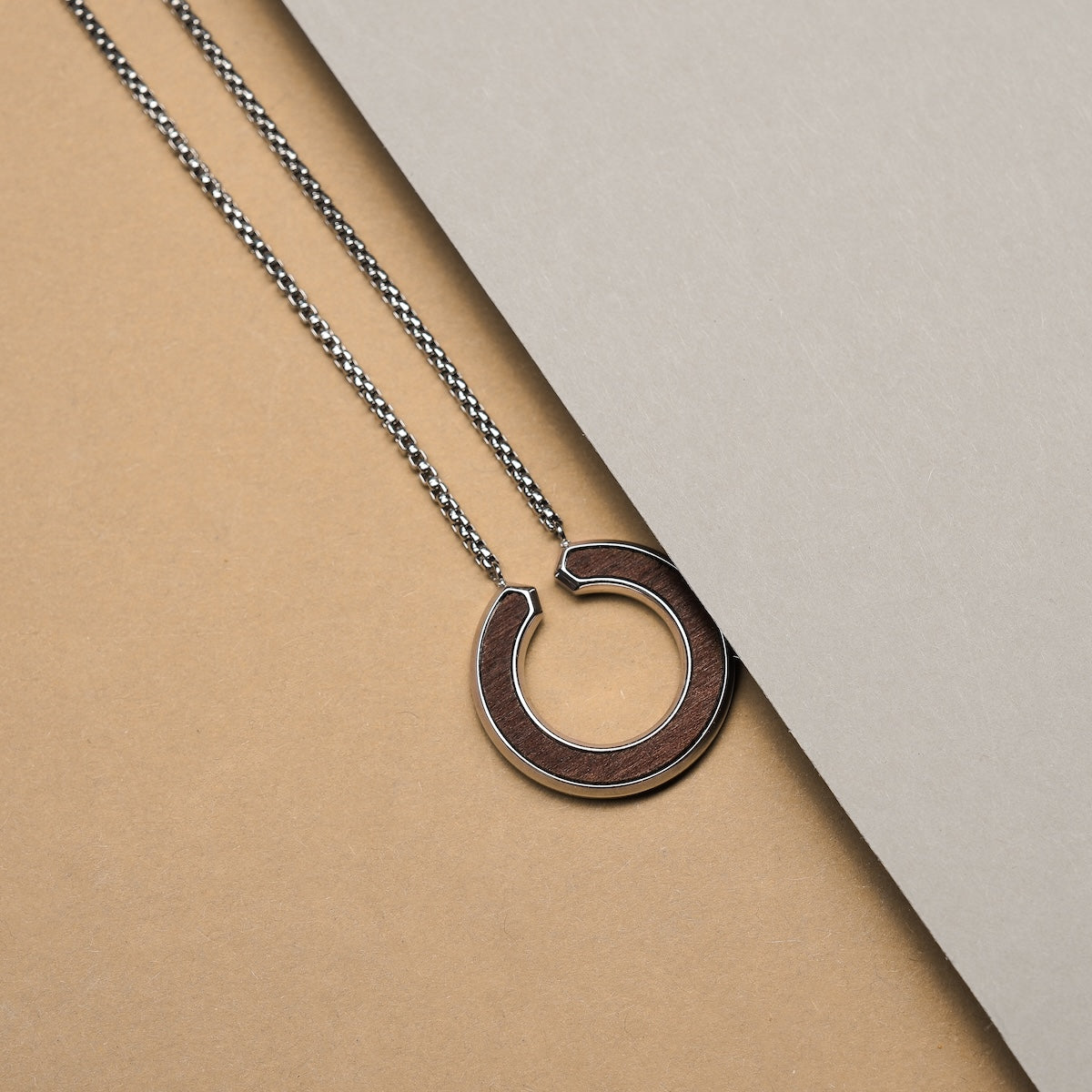 Collana "Inseparabile S" con un design in noce e argento con un elegante ciondolo circolare e catena.