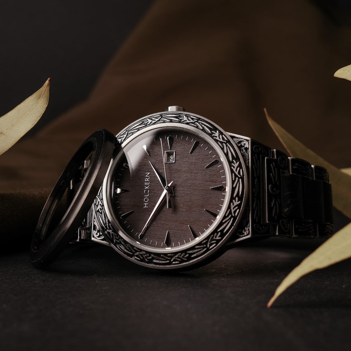 Orologio "Misir" con dettagli in argento intricati e finitura acero scuro, evidenziando il suo design elegante e sofisticato.