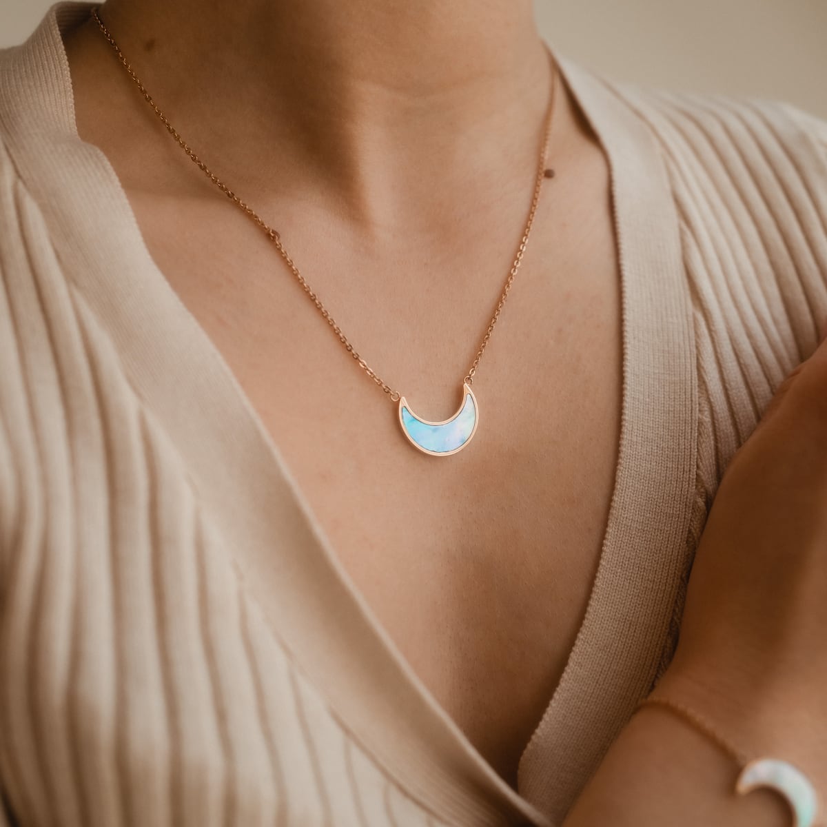 "Collana d'Uo": Elegante collana a mezzaluna in blu nacre con accenti in oro rosa.