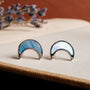 "Hand Orecchini": orecchini a forma di Crescent con finitura argentata e azzurra, design elegante e moderno.